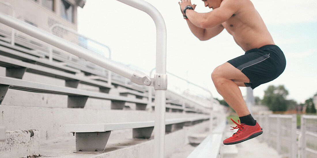 A man jumping over some steps on top of a bench.