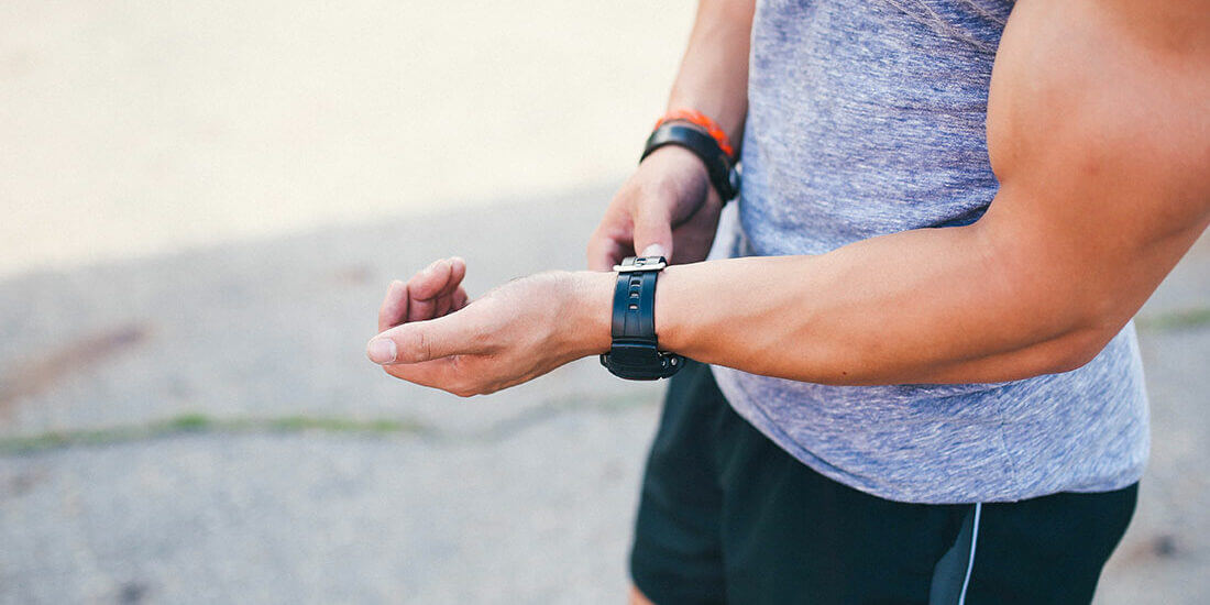 A man wearing an apple watch while standing next to another man.