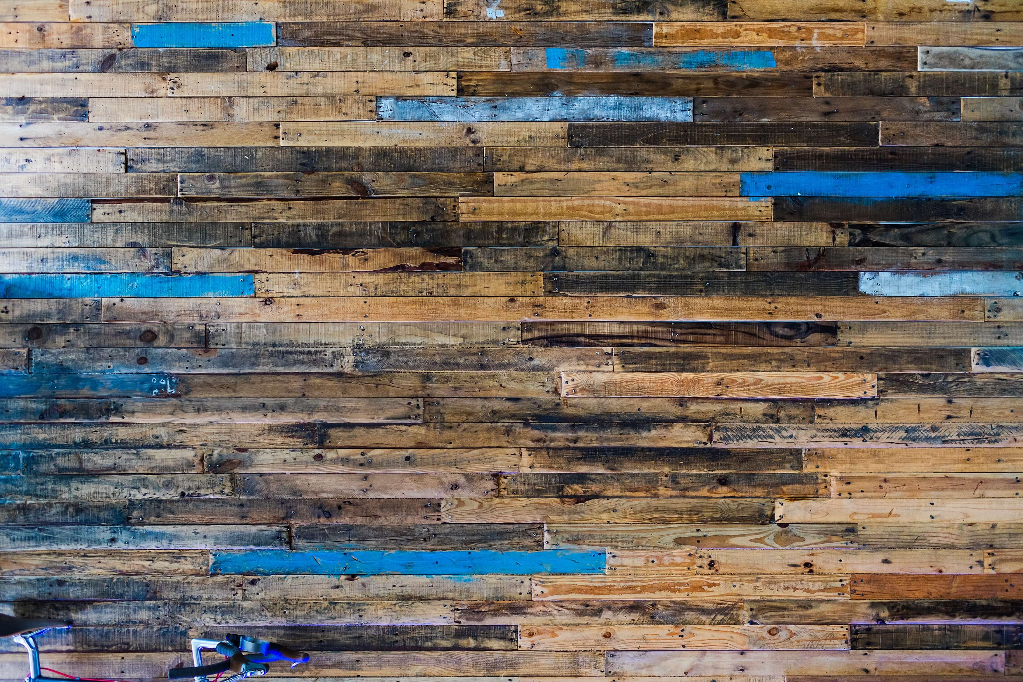 A wall with many different colored strips of wood.