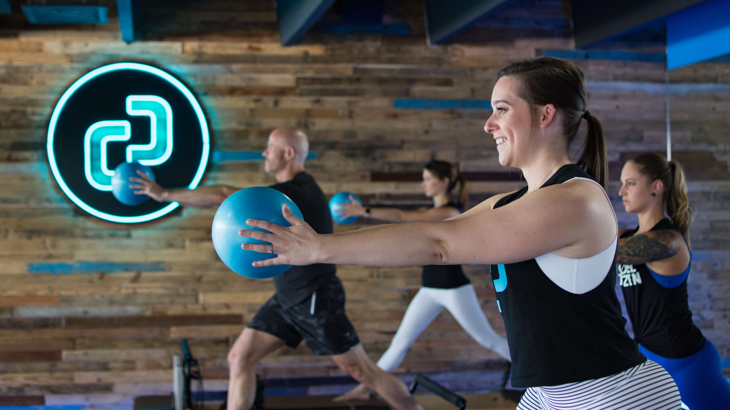 A group of people in a gym holding balls.
