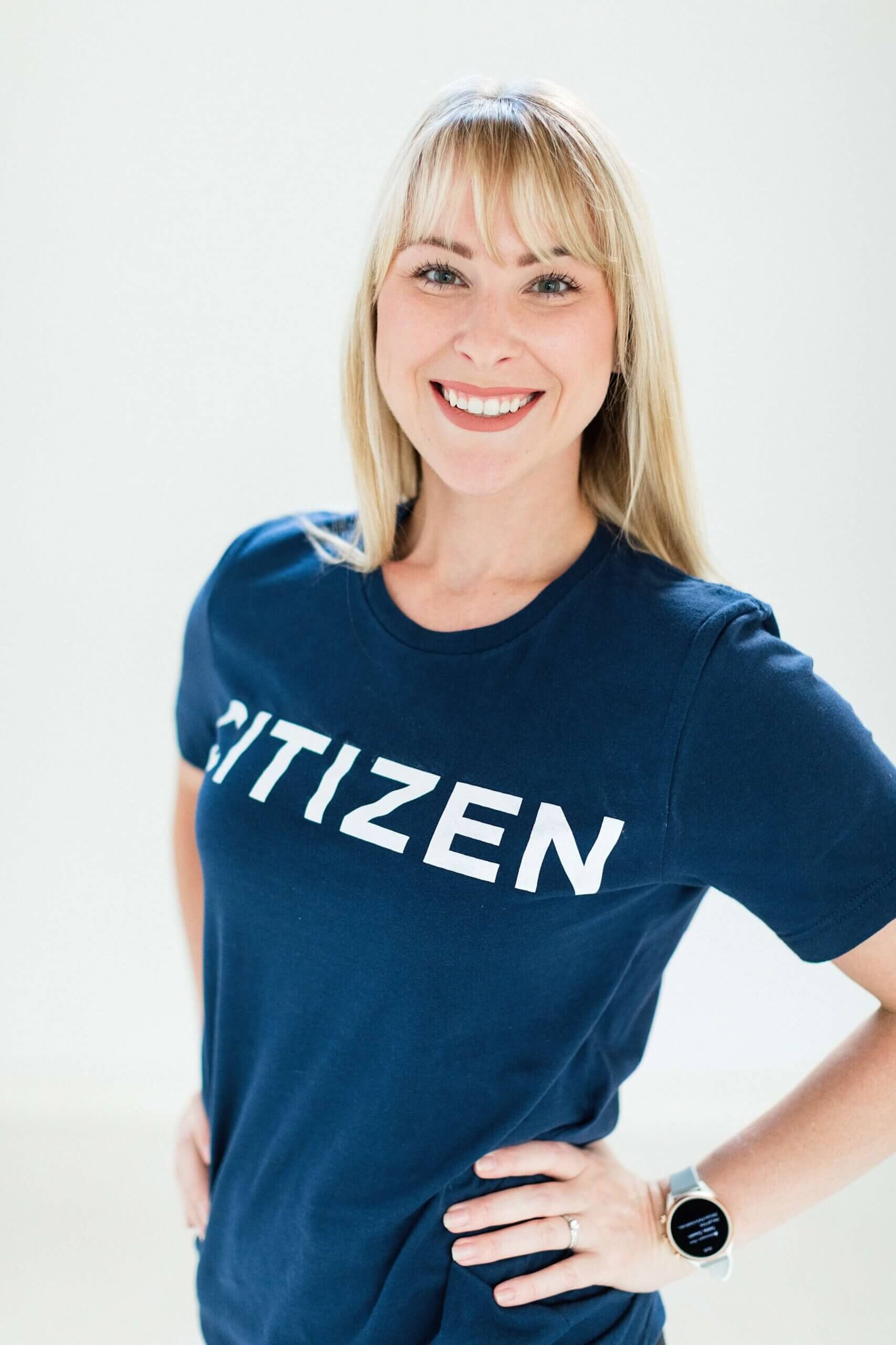 A woman wearing a citizen t-shirt smiling for the camera.