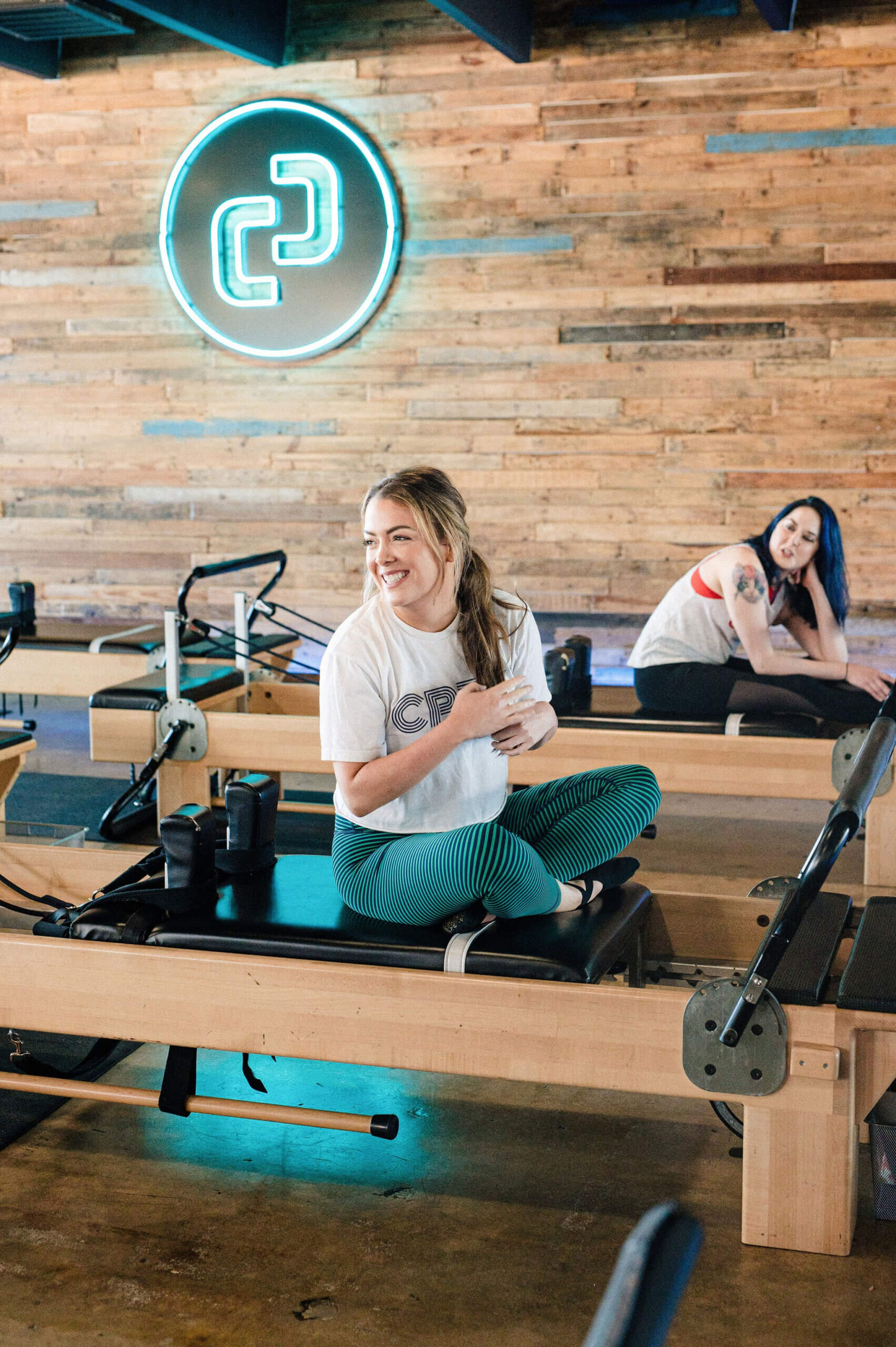 Rae sitting on a reformer at Citizen Pilates in Houston, smiling during her 600th class milestone