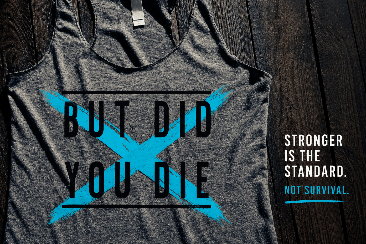 Gray workout tank top reading “But Did You Die” crossed out in blue with the phrase “Stronger Is the Standard, Not Survival” representing the difference between Lagree and reformer Pilates at Citizen Pilates Houston