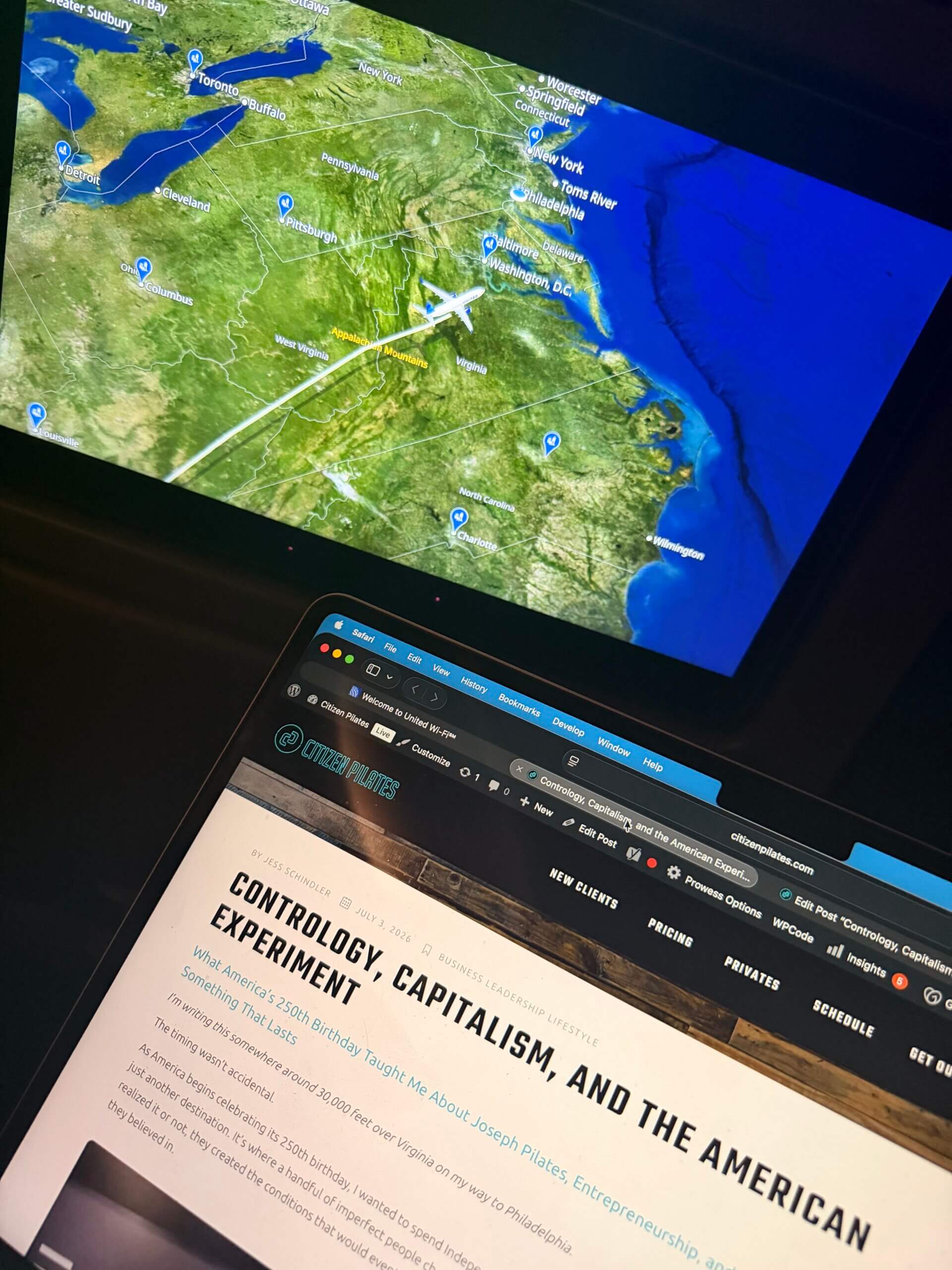 Jess Schindler writing "Contrology, Capitalism, and the American Experiment" aboard a flight over Virginia on the way to Philadelphia for America's 250th birthday celebration.